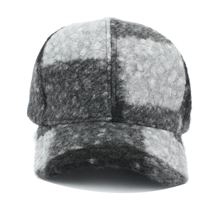Dettaglio del cappellino da baseball a quadri neri e grigi in caldo tessuto pile sherpa