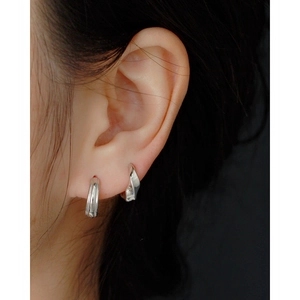 Detailed view of minimalist S925 sterling silver twisted hoop earrings worn on an ear