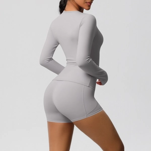 Détail d'un ensemble de yoga gris clair avec haut à manches longues et short taille haute