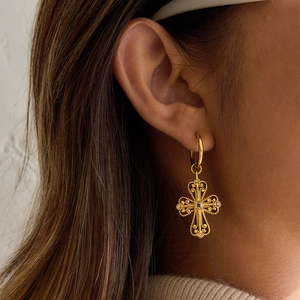 Vintage gold cross earrings with square crystal and intricate filigree on a female model