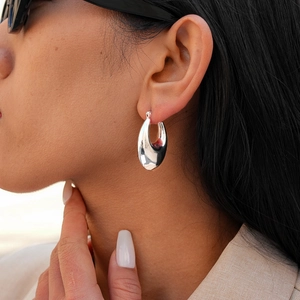 Chic silver polished teardrop hoop earrings for women shown on model with sleek metallic finish