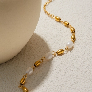 Detail of 18K gold stainless steel chain with alternating white freshwater pearls