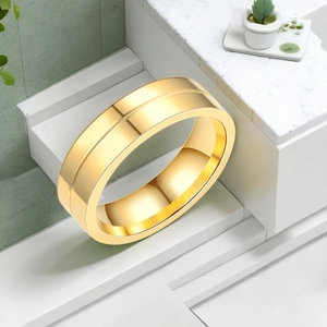 Gros plan d'une bague double anneau en or poli sur un support blanc minimaliste