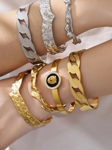 Close-up of gold lion head medallion bracelet with hammered texture bangles