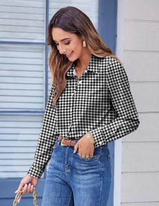 Detail of a chic long-sleeved houndstooth shirt with classic collar and front buttons