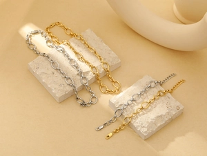 Macro detail of gold and silver chunky chain links with lobster clasp on stone