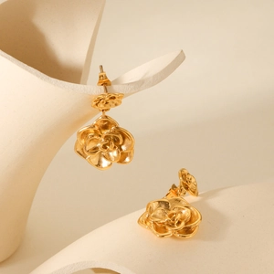 Elegant 18K gold plated stainless steel rose flower stud earrings on ceramic display