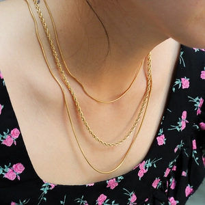 Three-layer 18K gold plated snake and twist chain necklace set on a female model