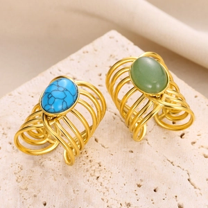 Vue macro détaillée de bagues en fil doré ornées de pierres turquoise bleues et vertes