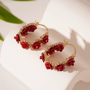 Detail of red rose hoop earrings with gold plating and sparkling white rhinestones