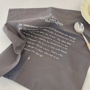 Detail of dark gray cotton linen placemat with minimalist white Scandinavian typography