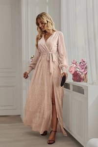 Pink sequin wrap dress with V-neckline and side slit detail shown in bright indoor setting