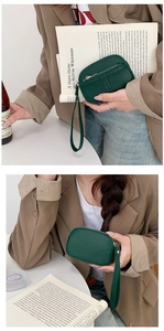 Detail of dark green pebble leather mini coin purse with wrist strap and zipper closure
