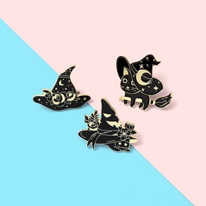 Detailed view of Halloween enamel pins featuring black cat and witch hat on bicolour background