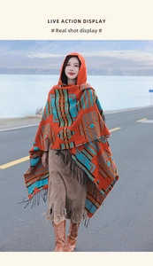 Detail of ethnic geometric jacquard pattern and black tassels on a hooded knit poncho