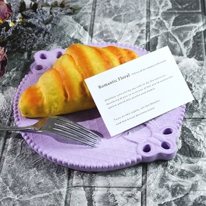 Modello realistico di croissant su piatto lavanda a rilievo con forchetta su marmo