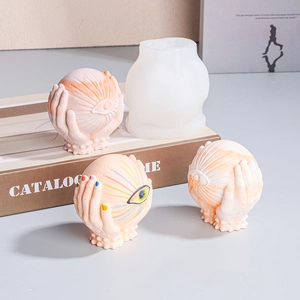 Detailed silicone mold for hands holding eyeball candle and finished plaster craft pieces