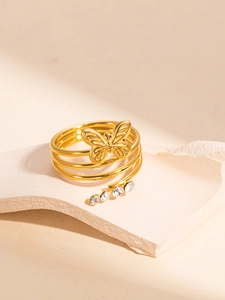 Close-up of golden multi-layer spiral ring with butterfly relief and zircon inlays
