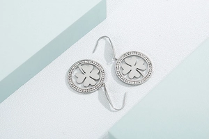 Detail of silver clover earrings with sparkling pavé crystals and polished round frame