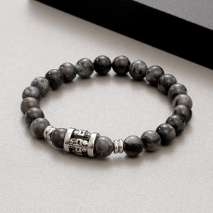 Macro shot of tiger eye beads and silver skull charm on an elastic beaded bracelet