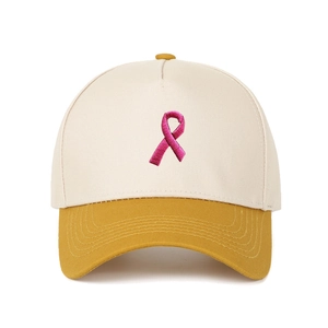 Detail der Stickerei mit rosa Schleife auf beiger und gelber 5-Panel-Baseballkappe