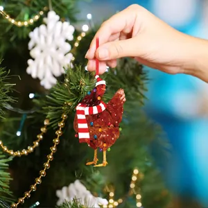 Funny chicken Christmas ornament with scarf and hat hanging on a decorated tree