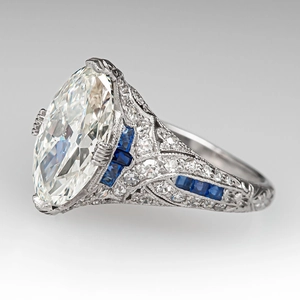 Macro shot of an Art Deco ring with oval center stone and blue sapphire accents