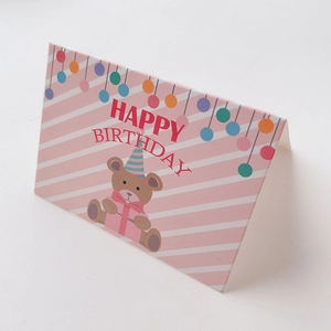 Close-up of pink mini birthday card featuring a cute cartoon bear and happy birthday text