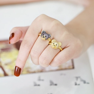Detail of two gold teddy bear rings with dark and gold pave crystals on model hand