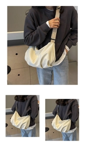 Detailed view of the beige crescent tote bag showing the soft texture and wide strap