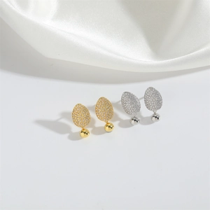 Detailed close-up of gold and silver plated stud earrings with pavé set cubic zirconia