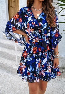 Detail view of floral chiffon dress featuring V-neckline and ruffled hemline