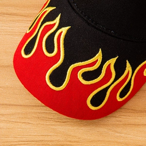 Macro view of flame embroidery detail on the brim of a black and red baseball cap