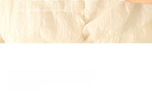 Détail en gros plan du tissu texturé crème pour collier à médaillon cœur vintage