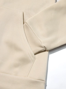 Dettagli dei polsini a costine e delle cuciture della tuta in pile beige uomo