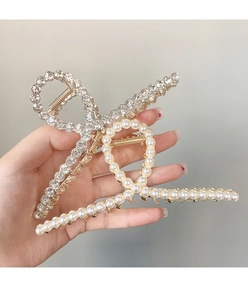 Détail de grandes pinces à cheveux en métal avec strass et perles élégantes