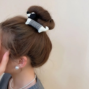 Detailed view of polka dot dachshund fabric hair clip worn on a bun hairstyle
