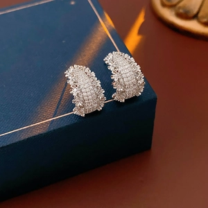 Gros plan de boucles d'oreilles C en argent avec zircons sur un coffret à bijoux de luxe