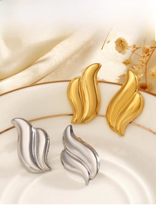 Detailed view of gold and silver irregular wave earrings on a porcelain dish
