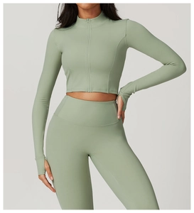 Détail de la veste de yoga vert sauge avec passe-pouces et col montant zippé