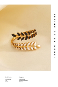 Detail of leaf ring featuring black and white enamel on a polished gold band