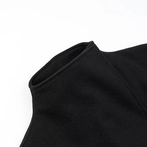 Detailopname van de zwarte opstaande kraag en premium stoftextuur van de lange overjas