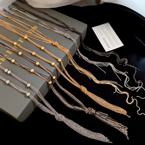 Detailed shot of multi-layered tassel necklaces with metallic beads in gold, silver, and black