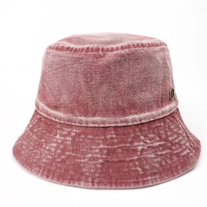 Detail of washed denim bucket hat in vintage burgundy with a bronze logo badge