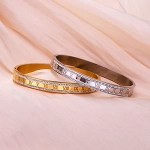 Detail of 18K gold and silver titanium steel bracelets with roman numerals and crystals