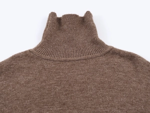 Gros plan du col roulé à fines côtes sur un pull en tricot de couleur marron