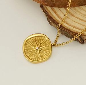 Detailed view of gold octagram star pendant with zircon on wooden texture background
