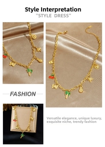 Detail of gold Figaro chain necklace with colorful enamel tropical fruit and sea pendants