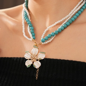 Vue détaillée du collier vintage avec perles turquoise et pendentif fleur en perles
