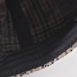 Macro detail of baseball cap inner lining with brown plaid fabric and stitched sweatband